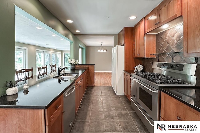 437 S 90th St, Omaha, NE 68114 - kitchen featuring stainless steel appliances, recessed lighting, backsplash, brown cabinetry, and dark stone countertops