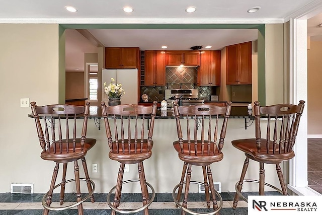 437 S 90th St, Omaha, NE 68114 - kitchen featuring freestanding refrigerator, dark countertops, recessed lighting, stainless steel range with gas stovetop, and tasteful backsplash