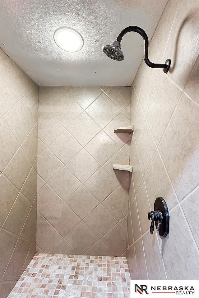 437 S 90th St, Omaha, NE 68114 - bathroom featuring a textured ceiling and tiled shower