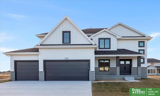 5721 N 197th Ave, Omaha, NE 68022 - view of front of property with concrete driveway, board and batten siding, roof with shingles, a porch, and an attached garage