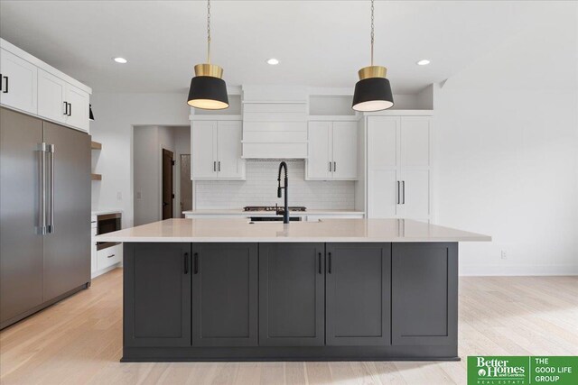 5721 N 197th Ave, Omaha, NE 68022 - kitchen featuring high quality fridge, white cabinets, tasteful backsplash, light countertops, and light wood-type flooring
