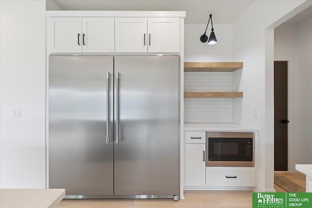 5721 N 197th Ave, Omaha, NE 68022 - kitchen with built in appliances, white cabinetry, backsplash, and light countertops