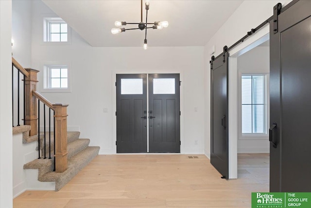 5721 N 197th Ave, Omaha, NE 68022 - entrance foyer with a barn door, a chandelier, stairs, and light wood finished floors