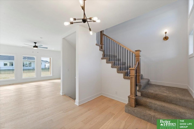 5721 N 197th Ave, Omaha, NE 68022 - staircase featuring wood finished floors, a chandelier, and ceiling fan
