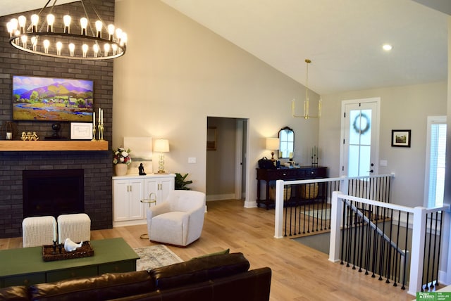 5445 Kestrel Pkwy, Omaha, NE 68022 - living area featuring a chandelier, high vaulted ceiling, light wood-type flooring, and a fireplace