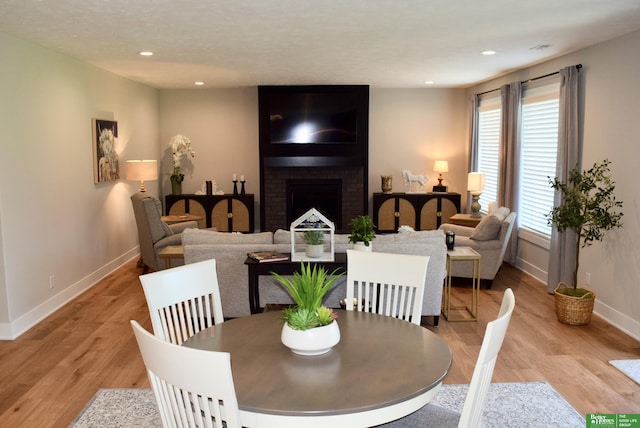 5445 Kestrel Pkwy, Omaha, NE 68022 - dining space with a fireplace, recessed lighting, and light wood finished floors