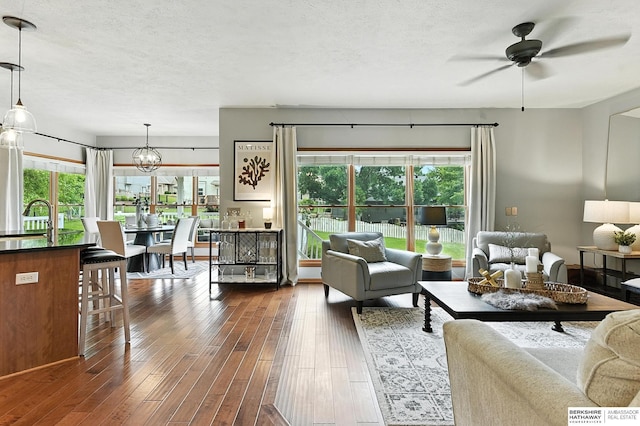 17534 Jefferson St, Omaha, NE 68135 - living area featuring healthy amount of natural light, dark wood-style flooring, a ceiling fan, a textured ceiling, and a chandelier