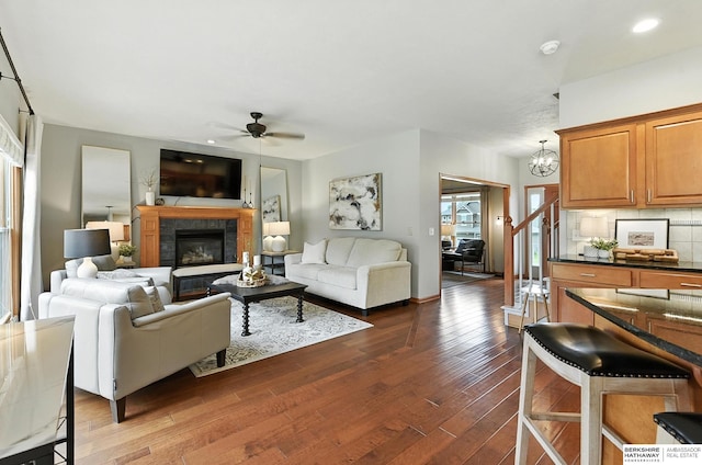17534 Jefferson St, Omaha, NE 68135 - living area with ceiling fan, dark wood-style floors, a chandelier, and a glass covered fireplace