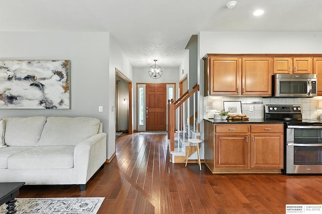 17534 Jefferson St, Omaha, NE 68135 - kitchen with appliances with stainless steel finishes, a chandelier, open floor plan, brown cabinets, and dark countertops