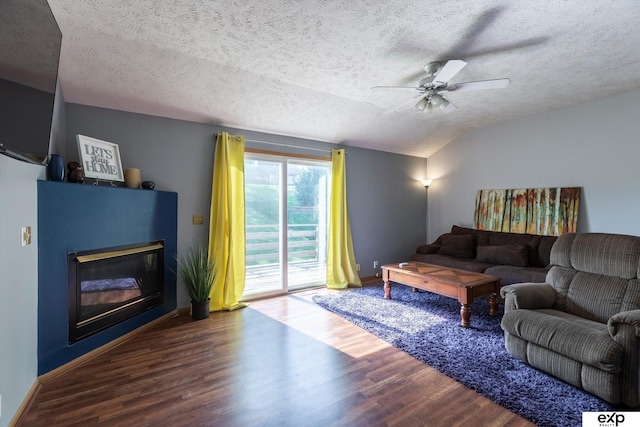 6633 N 115th St, Omaha, NE 68164 - living area with a glass covered fireplace, wood finished floors, a textured ceiling, a ceiling fan, and lofted ceiling
