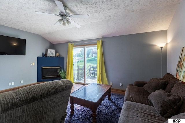 6633 N 115th St, Omaha, NE 68164 - living room with vaulted ceiling, a textured ceiling, a glass covered fireplace, ceiling fan, and wood finished floors