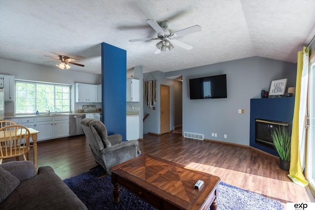 6633 N 115th St, Omaha, NE 68164 - living area featuring ceiling fan, a textured ceiling, dark wood finished floors, vaulted ceiling, and a glass covered fireplace