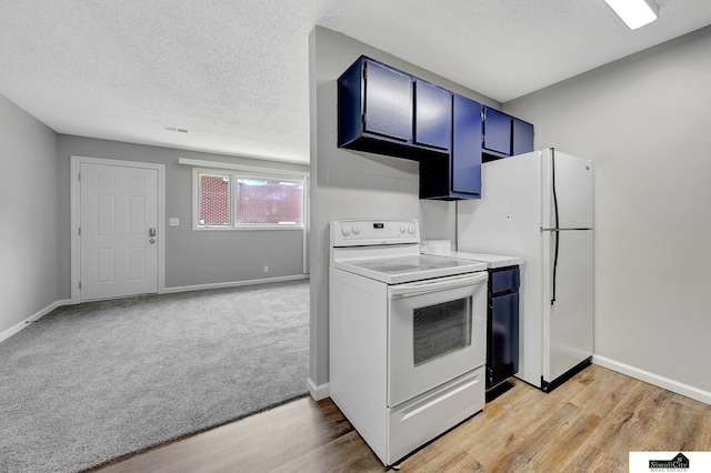 1207 B St, Lincoln, NE 68502 - kitchen with white appliances, blue cabinetry, light countertops, light wood finished floors, and light carpet