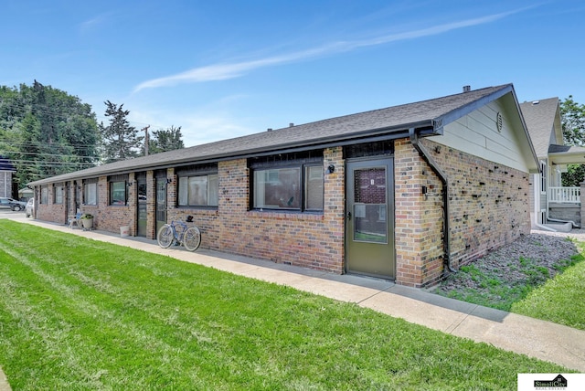 1207 B St, Lincoln, NE 68502 - ranch-style house with brick siding, a front yard, and roof with shingles
