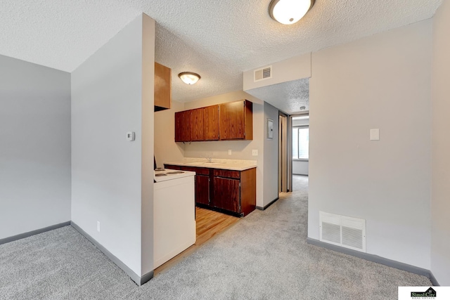 1207 B St, Lincoln, NE 68502 - kitchen with stove, light colored carpet, a textured ceiling, and light countertops