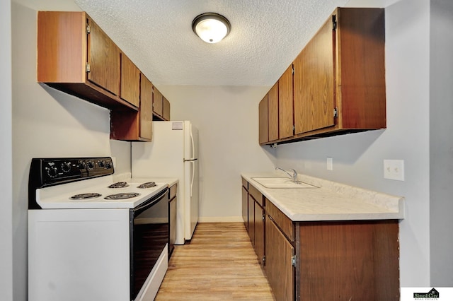 1207 B St, Lincoln, NE 68502 - kitchen featuring electric range, a textured ceiling, light countertops, light wood-type flooring, and brown cabinetry
