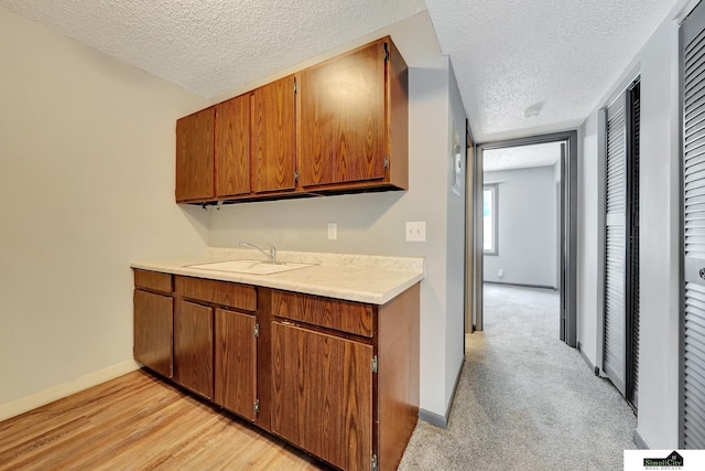 1207 B St, Lincoln, NE 68502 - kitchen featuring a textured ceiling, light countertops, and brown cabinets