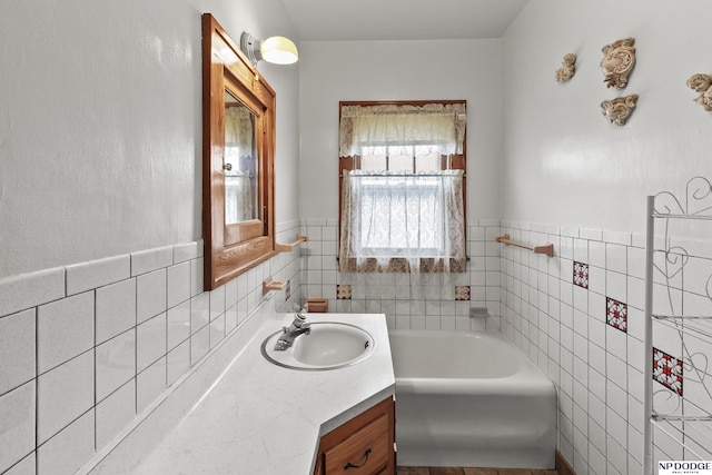 1107 E 1st St, Fremont, NE 68025 - bathroom with tile walls, a garden tub, vanity, and a wainscoted wall