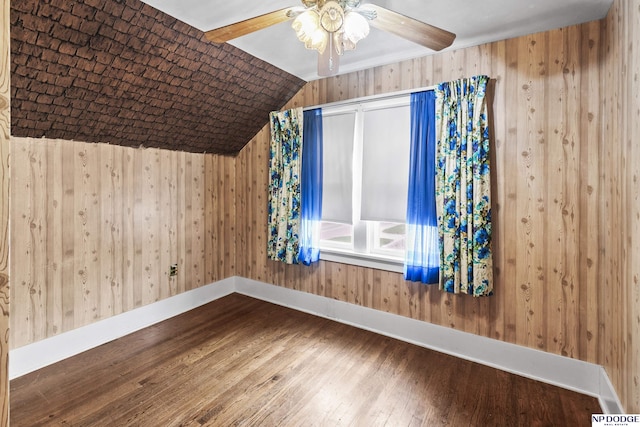 1107 E 1st St, Fremont, NE 68025 - bonus room featuring wood-type flooring, a ceiling fan, lofted ceiling, and wooden walls