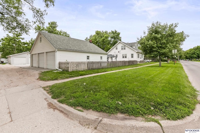 1107 E 1st St, Fremont, NE 68025 - view of home's exterior featuring a detached garage, a shingled roof, and an outdoor structure