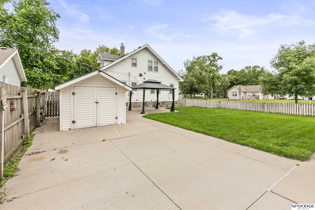 1107 E 1st St, Fremont, NE 68025 - rear view of house featuring a patio area, a gazebo, a storage unit, a chimney, and a fenced backyard