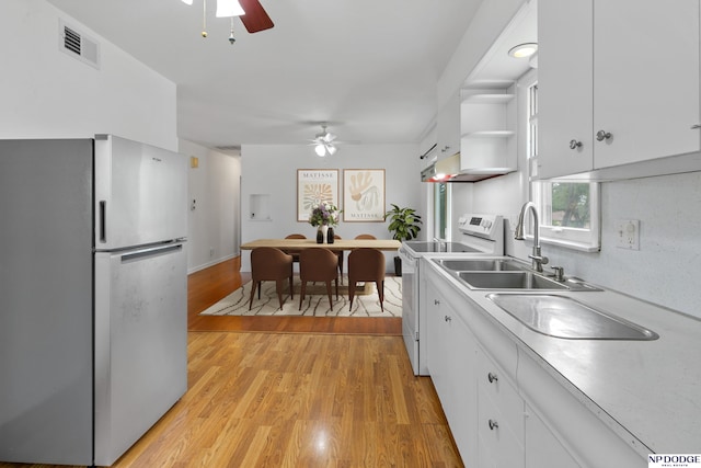 7922 Himebaugh Ave, Omaha, NE 68134 - kitchen with freestanding refrigerator, white electric stove, ceiling fan, and white cabinetry
