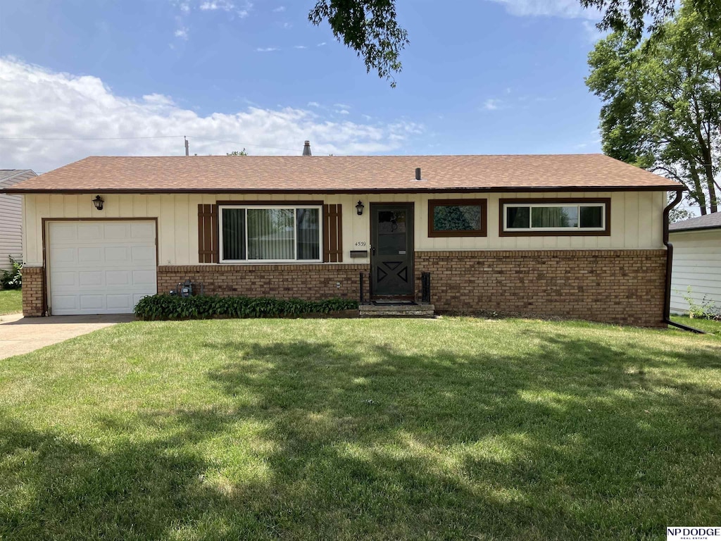 4539 Krug Ave, Omaha, NE 68106 - ranch-style home with brick siding, an attached garage, a front yard, and driveway