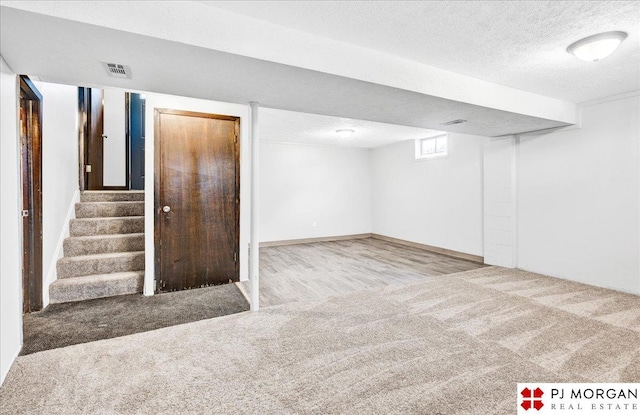 14030 Orchard Ave, Omaha, NE 68137 - below grade area featuring carpet flooring, a textured ceiling, and stairway