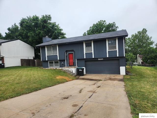 5020 N 106th St, Omaha, NE 68134 - split foyer home featuring a garage, concrete driveway, and a chimney