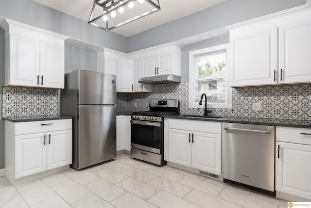 3207 Castelar St, Omaha, NE 68105 - kitchen featuring appliances with stainless steel finishes, under cabinet range hood, dark countertops, and white cabinets