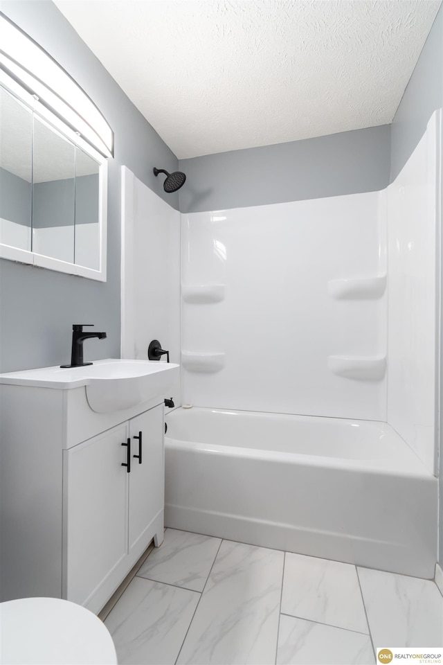 3207 Castelar St, Omaha, NE 68105 - bathroom with marble finish flooring, vanity, washtub / shower combination, and a textured ceiling