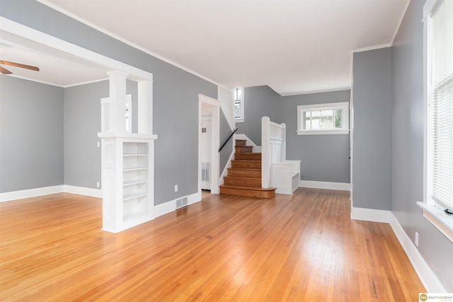 3207 Castelar St, Omaha, NE 68105 - unfurnished living room with light wood-style flooring, ceiling fan, stairs, and crown molding
