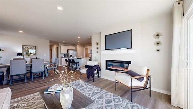 11470 Port Royal Dr, Papillion, NE 68046 - living area featuring wood finished floors, a glass covered fireplace, and recessed lighting