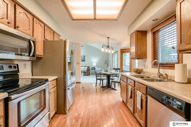 5001 W Sparrow Ln, Lincoln, NE 68528 - kitchen with stainless steel appliances, light countertops, light wood-type flooring, a chandelier, and vaulted ceiling