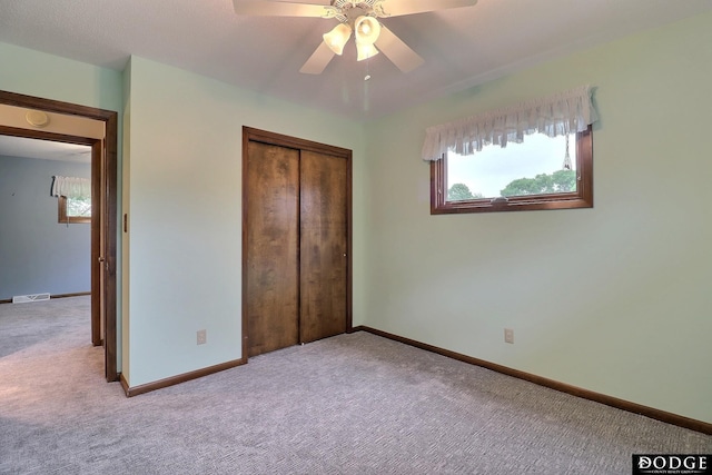 2204 Bramblewood Ln, Fremont, NE 68025 - unfurnished bedroom with carpet flooring, multiple windows, a closet, and a ceiling fan