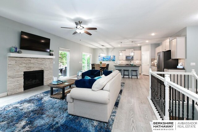 10818 S 109th St, Papillion, NE 68046 - living area with light wood-style flooring, a ceiling fan, recessed lighting, and a stone fireplace