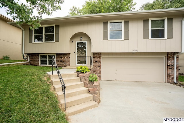 10929 V St, Omaha, NE 68137 - raised ranch featuring a garage, brick siding, driveway, and a front yard