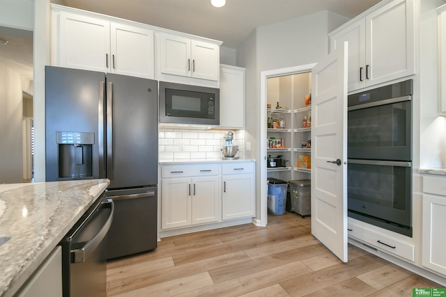 5017 N 209th St, Elkhorn, NE 68022 - kitchen featuring black appliances, light wood-type flooring, white cabinetry, light stone countertops, and decorative backsplash