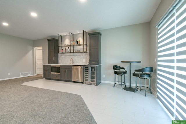 5017 N 209th St, Elkhorn, NE 68022 - indoor wet bar featuring appliances with stainless steel finishes, beverage cooler, decorative backsplash, and recessed lighting