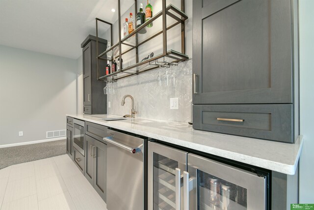 5017 N 209th St, Elkhorn, NE 68022 - indoor wet bar featuring stainless steel appliances, backsplash, beverage cooler, and light colored carpet