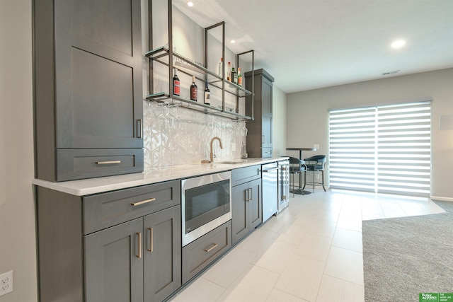 5017 N 209th St, Elkhorn, NE 68022 - kitchen featuring stainless steel microwave, light countertops, backsplash, gray cabinets, and recessed lighting