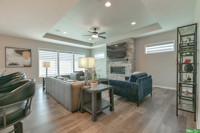 5017 N 209th St, Elkhorn, NE 68022 - living room featuring a raised ceiling, a fireplace, ceiling fan, light wood-style flooring, and recessed lighting