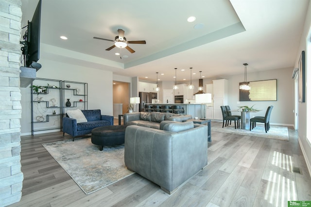 5017 N 209th St, Elkhorn, NE 68022 - living area with a raised ceiling, a ceiling fan, light wood finished floors, and recessed lighting