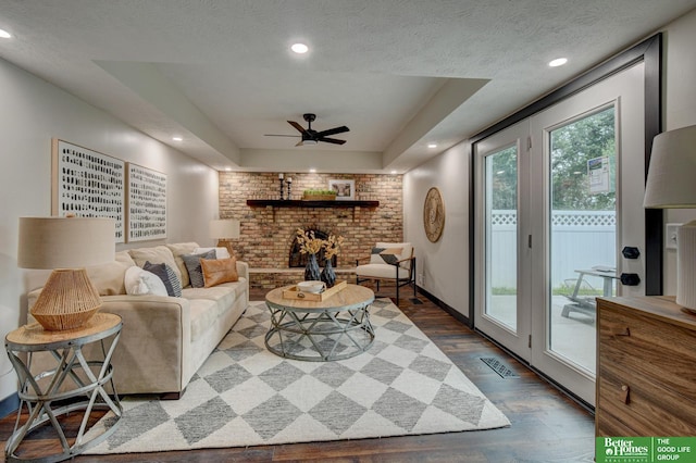 11680 Meredith Ave, Omaha, NE 68164 - living room featuring wood finished floors, ceiling fan, recessed lighting, a fireplace, and a raised ceiling