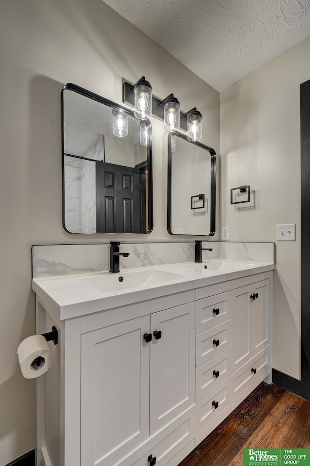 11680 Meredith Ave, Omaha, NE 68164 - bathroom with wood finished floors, double vanity, and a textured ceiling