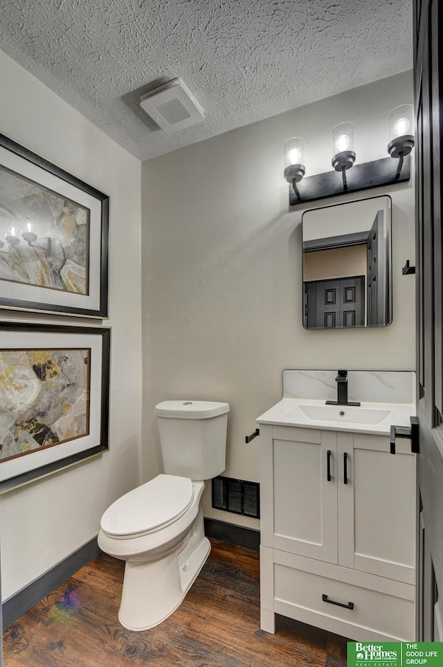 11680 Meredith Ave, Omaha, NE 68164 - half bathroom featuring vanity, wood finished floors, and a textured ceiling