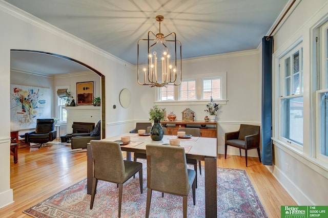 526 S 51st Ave, Omaha, NE 68132 - dining area featuring light wood finished floors, arched walkways, a fireplace, ornamental molding, and a chandelier