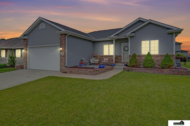 1015 Ridge Rd, Hickman, NE 68372 - ranch-style home featuring driveway, brick siding, a garage, a lawn, and roof with shingles