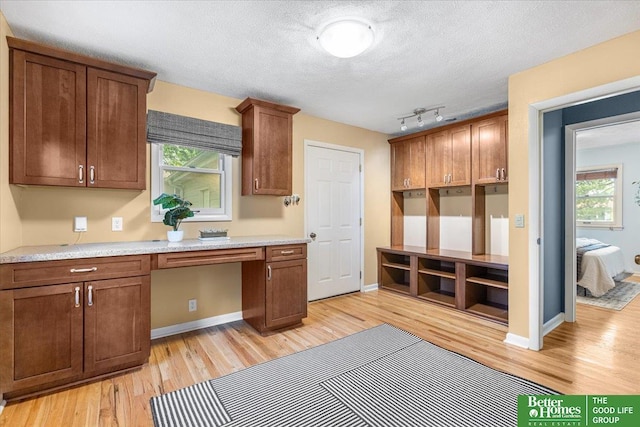 12079 Westover Rd, Omaha, NE 68154 - kitchen featuring light wood finished floors, healthy amount of natural light, light countertops, a textured ceiling, and built in study area