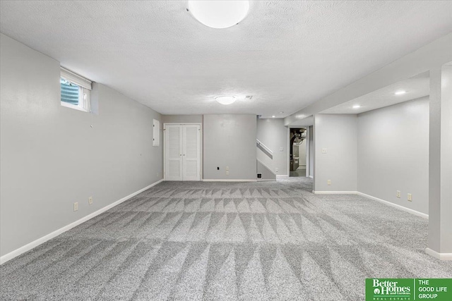 12079 Westover Rd, Omaha, NE 68154 - below grade area with carpet floors, a textured ceiling, stairway, and recessed lighting